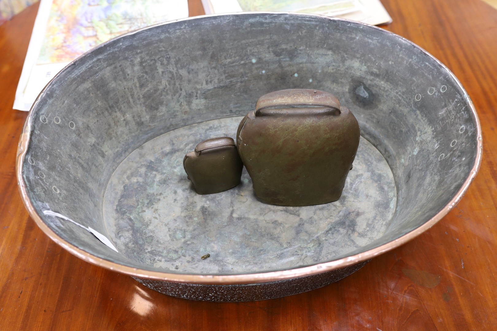 A copper twin handled pail and cow bells